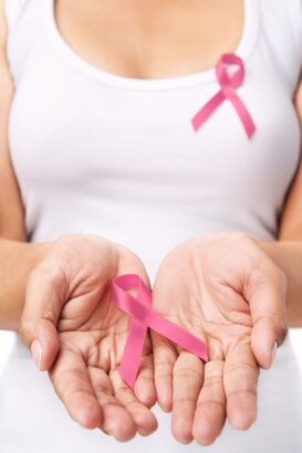 Hands holding pink ribbon symbol