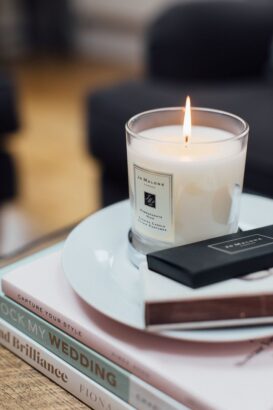 Candle on stack of wedding magazines.