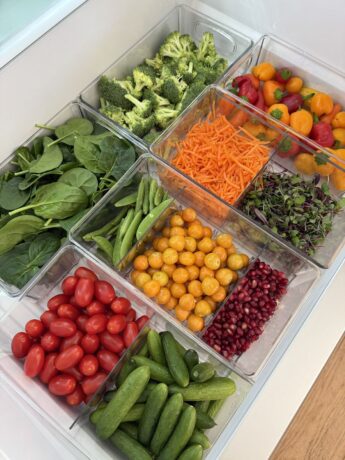 Simple fridge organization ideas with clear containers, fresh vegetables, fruit, and neatly arranged produce for a clean organized refrigerator.