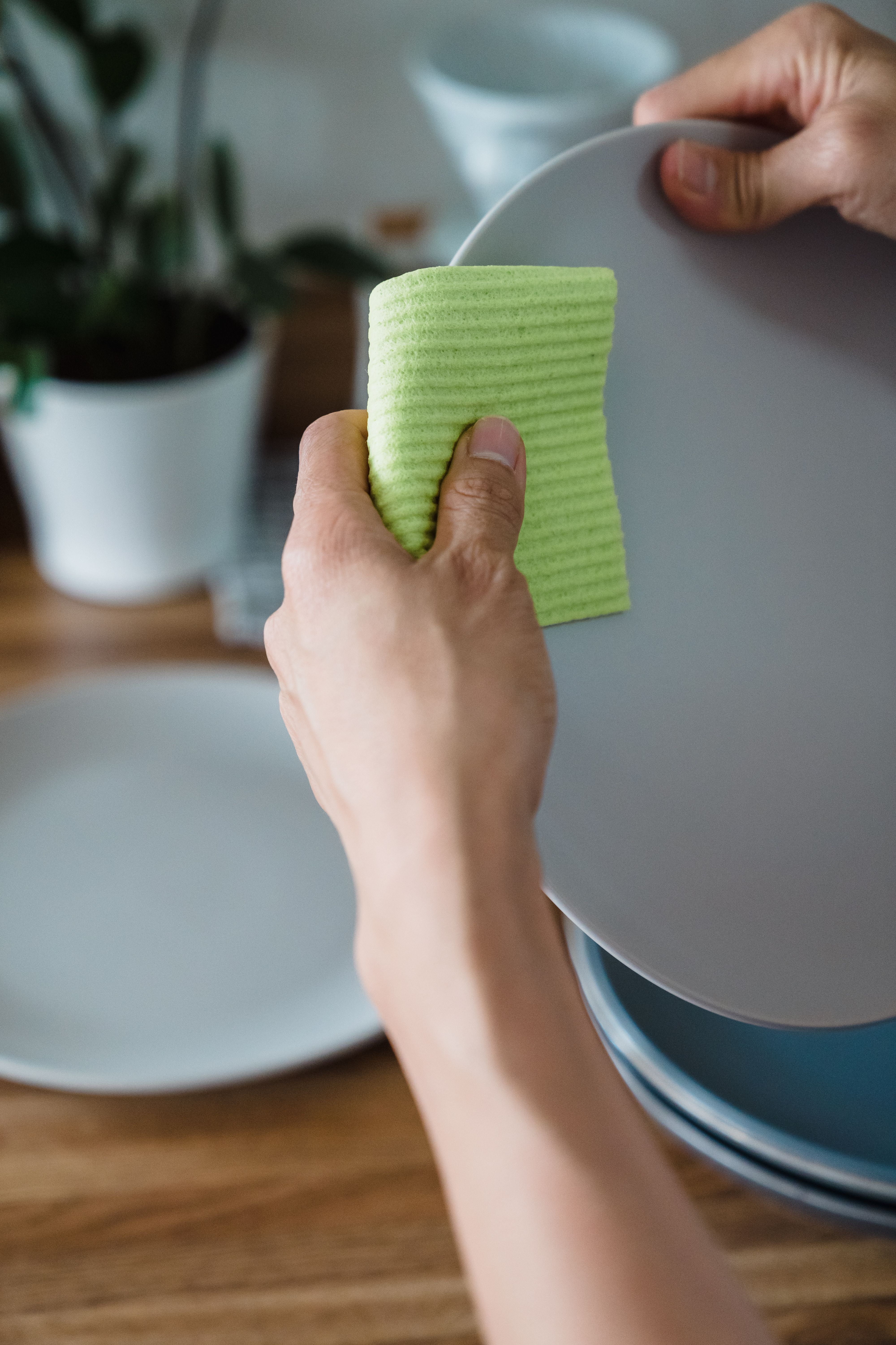 wiping kitchen counter with a dedicated microfiber cloth