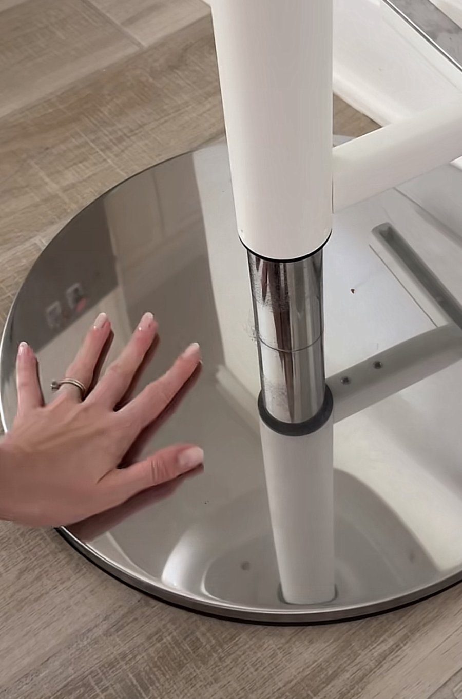 Wiping a chrome stool base with a yellow microfiber cloth