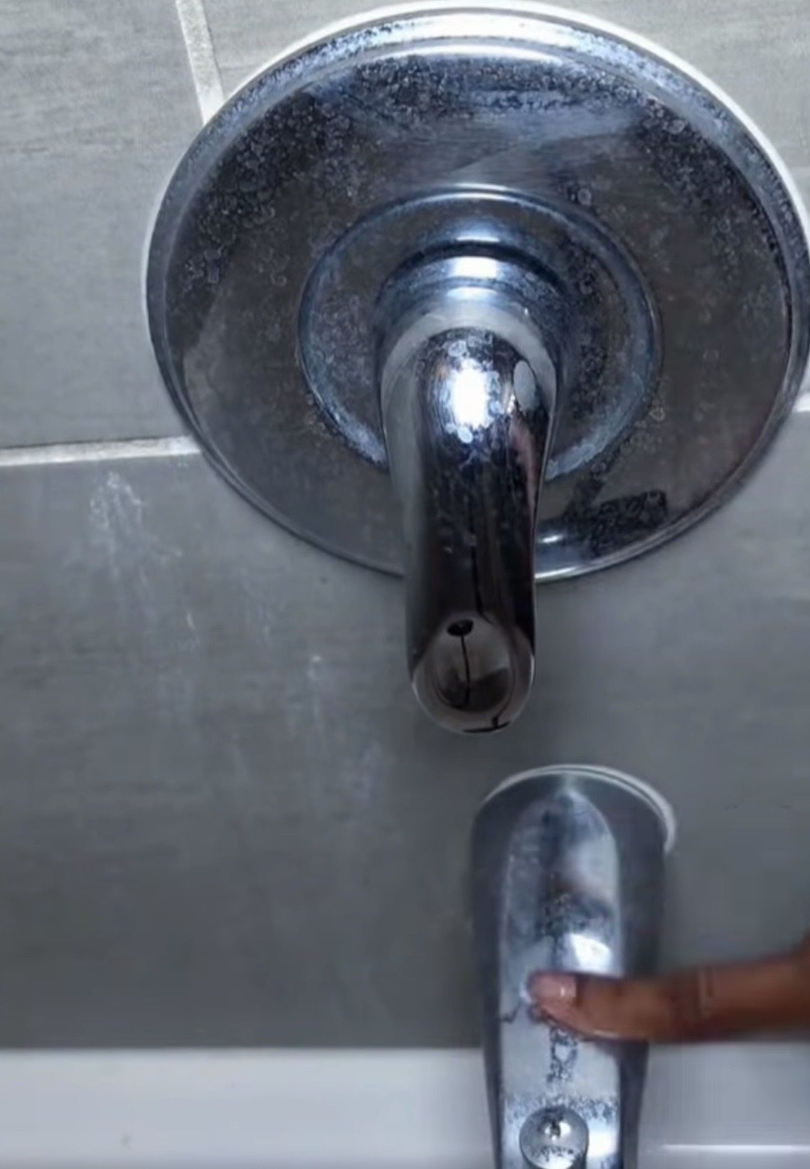 Shower faucet covered in limescale buildup before cleaning