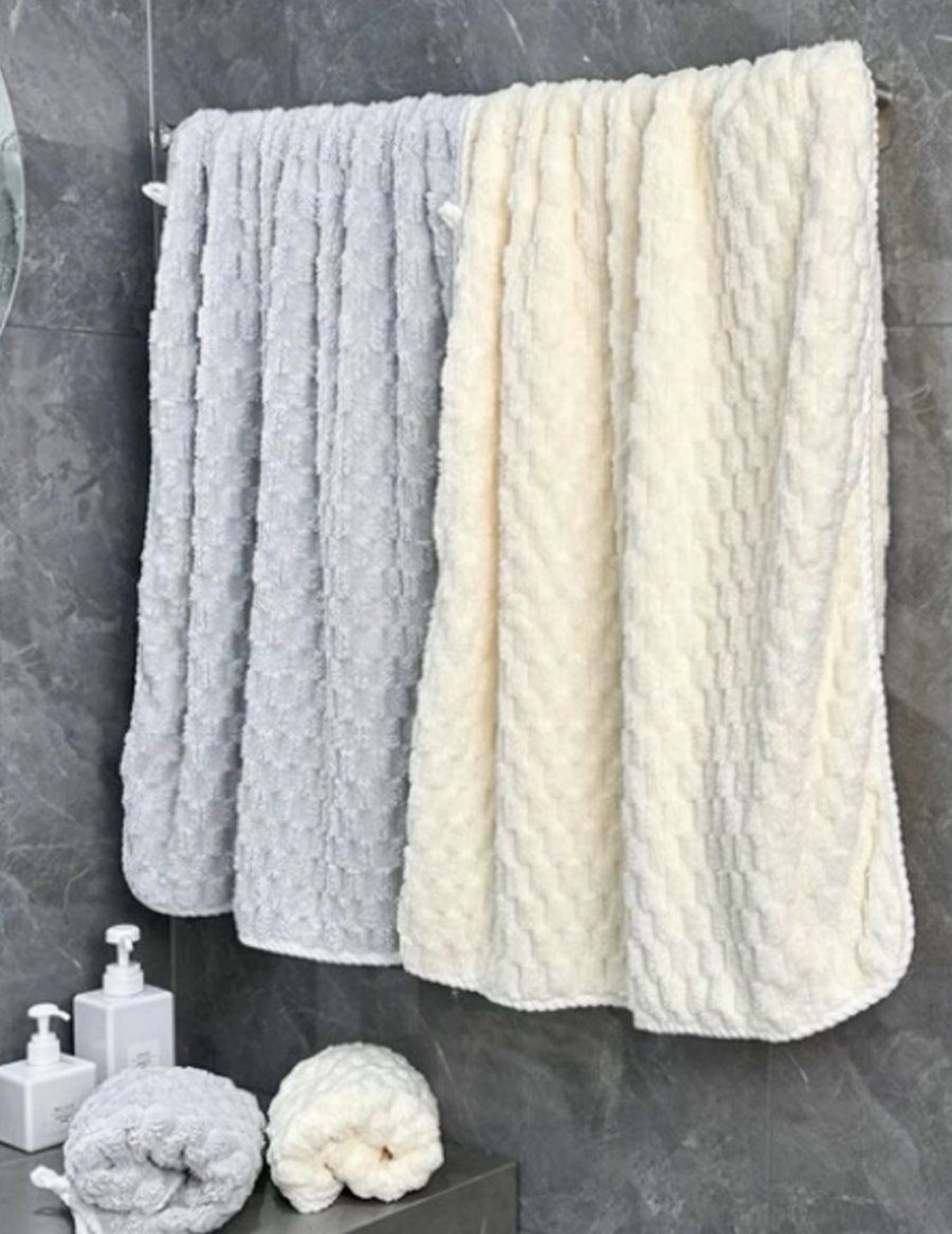 Soft fluffy towels hanging on a bathroom towel bar after washing