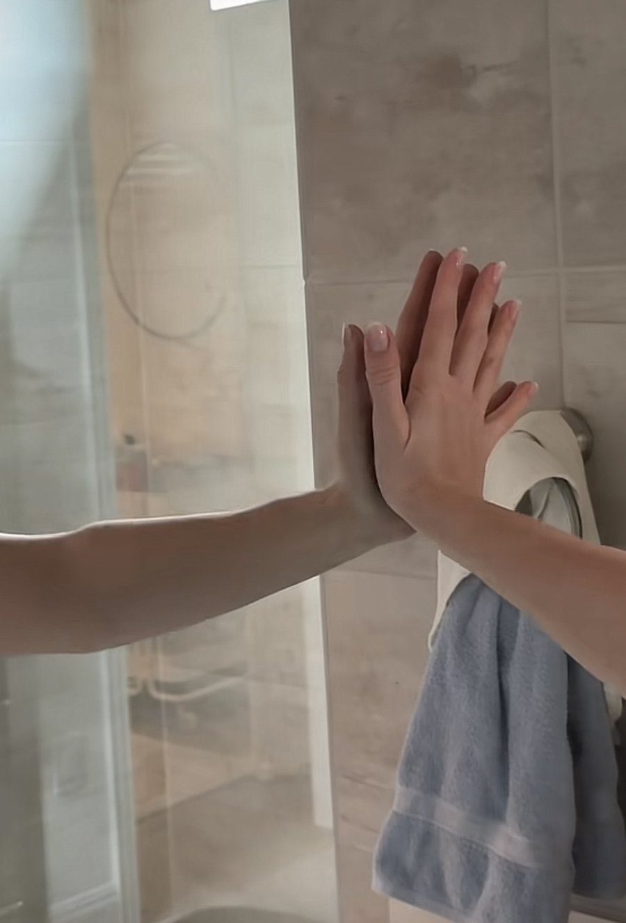 Clean mirror after wiping, hands pressed on the glass to check for fingerprints