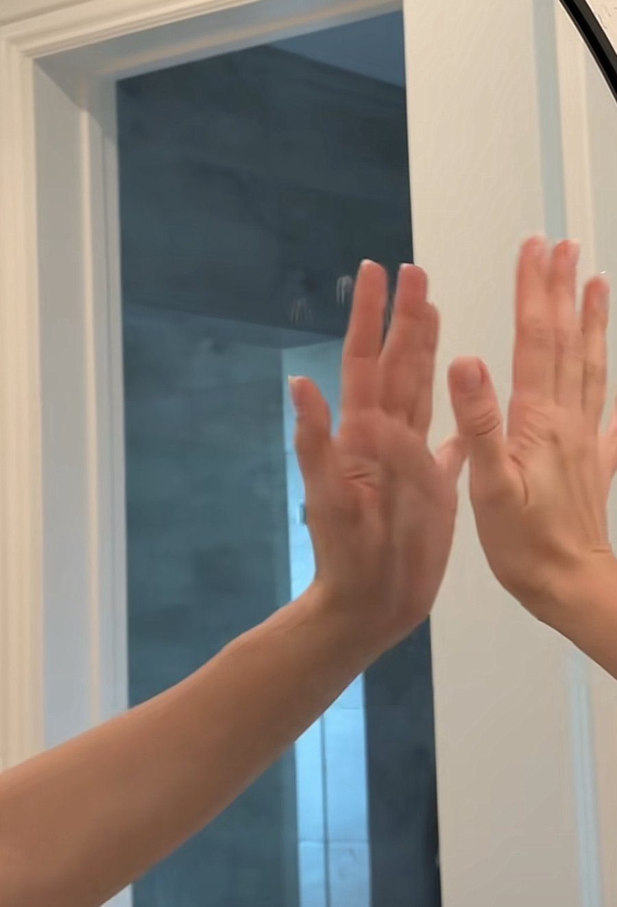 Wiping a mirror with homemade window cleaner and a yellow microfiber cloth